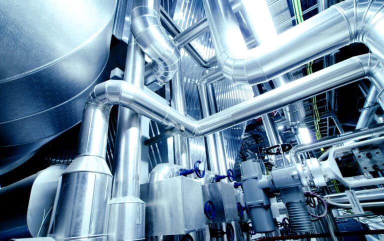 An industrial warehouse full of steel pipelines, valves, and machinery