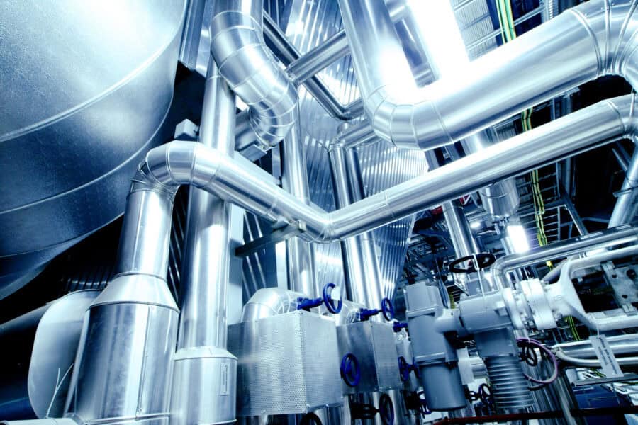 An industrial warehouse full of steel pipelines, valves, and machinery